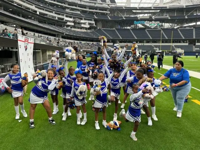 Cheer squad holding plush toys on field