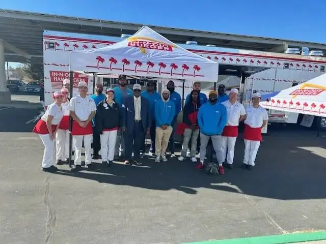 Team gathered outside burger stand